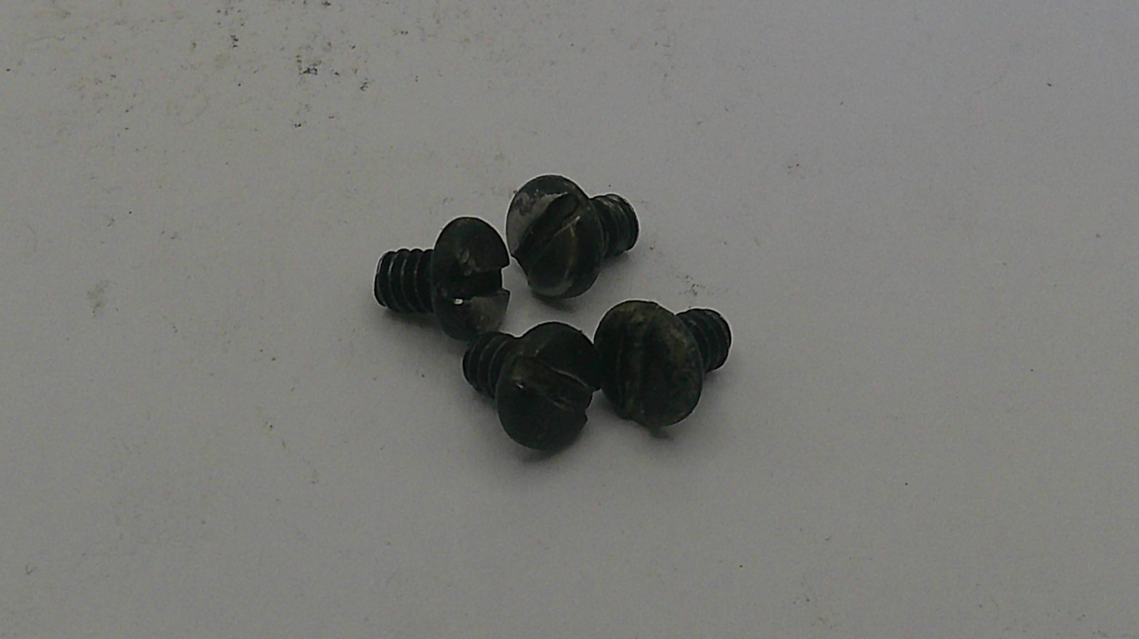 Small black screws on a light gray background