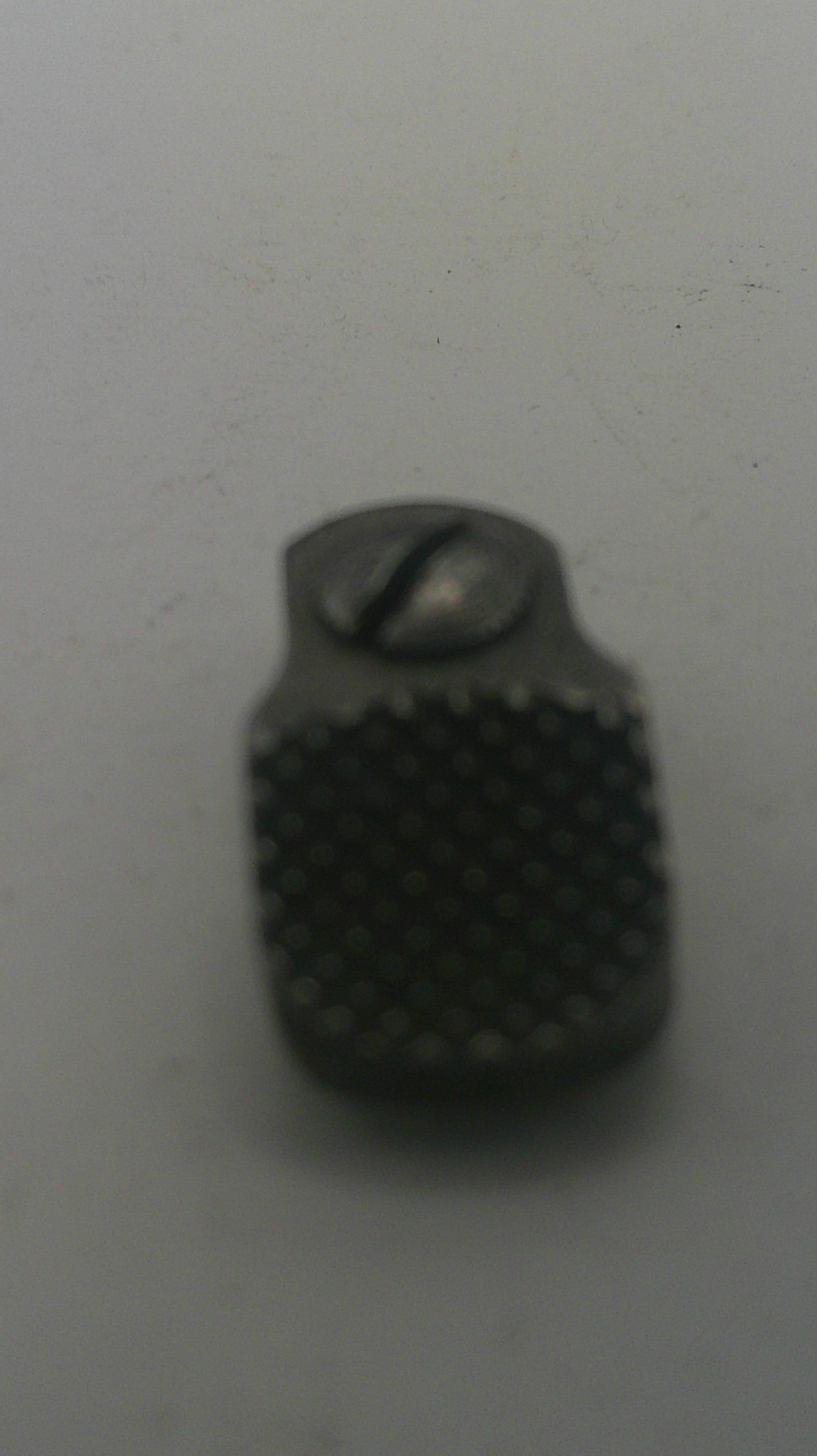 Black textured object on a light gray background