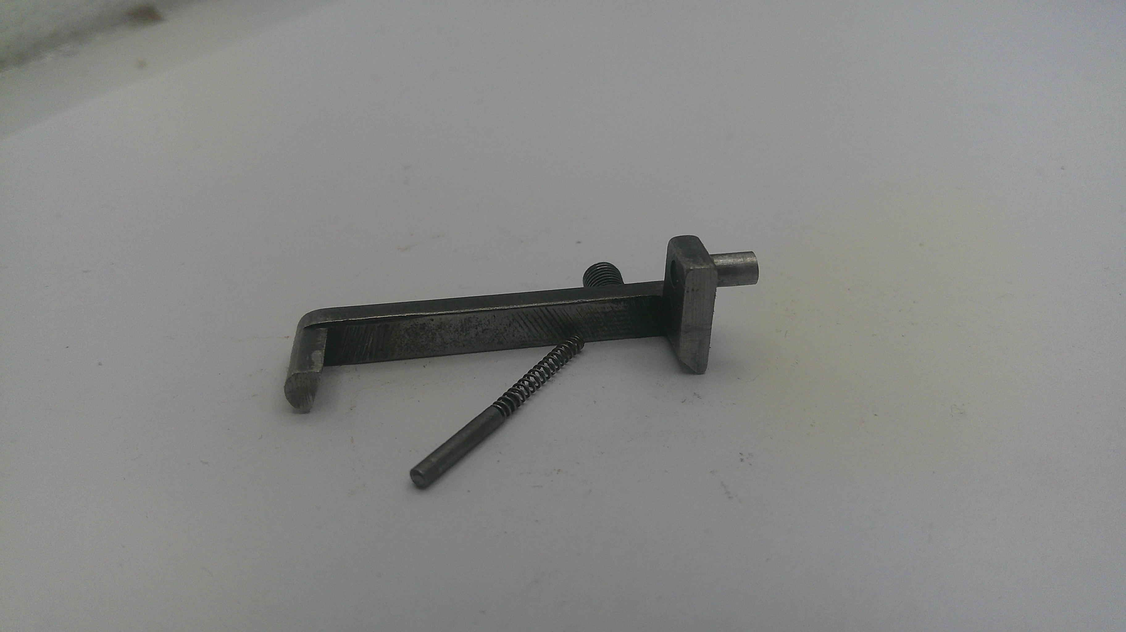 Metal tool with a screw on a light gray background