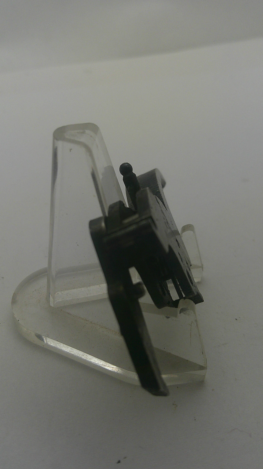 A clear plastic protective cover with a black metal and plastic internal component, photographed on a plain white background.