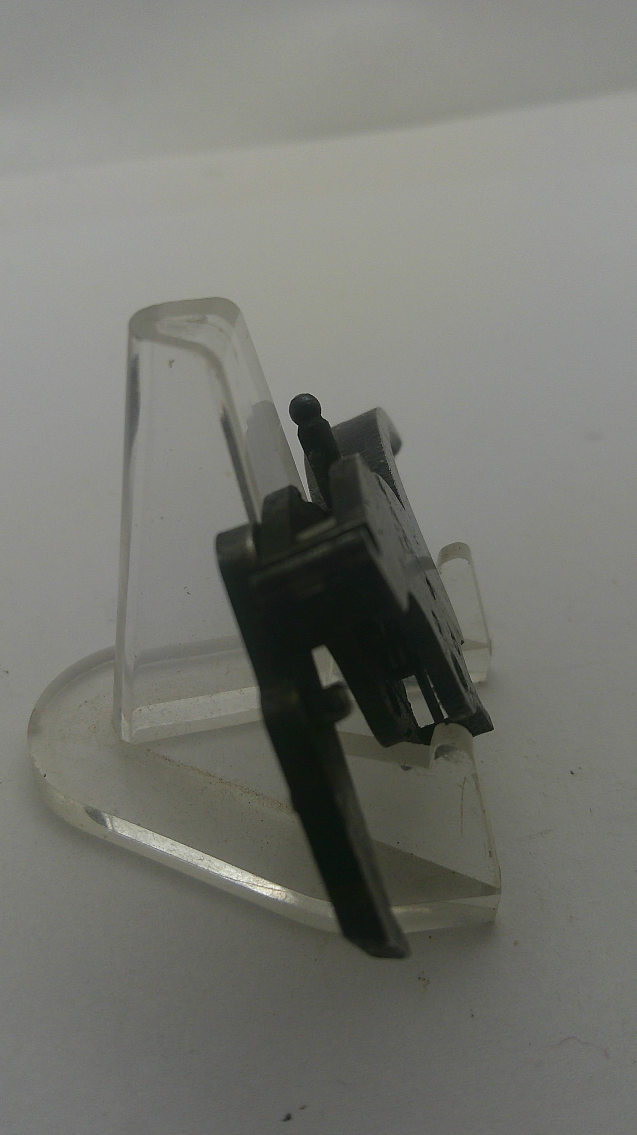 A clear plastic protective cover with a black metal and plastic internal component, photographed on a plain white background.