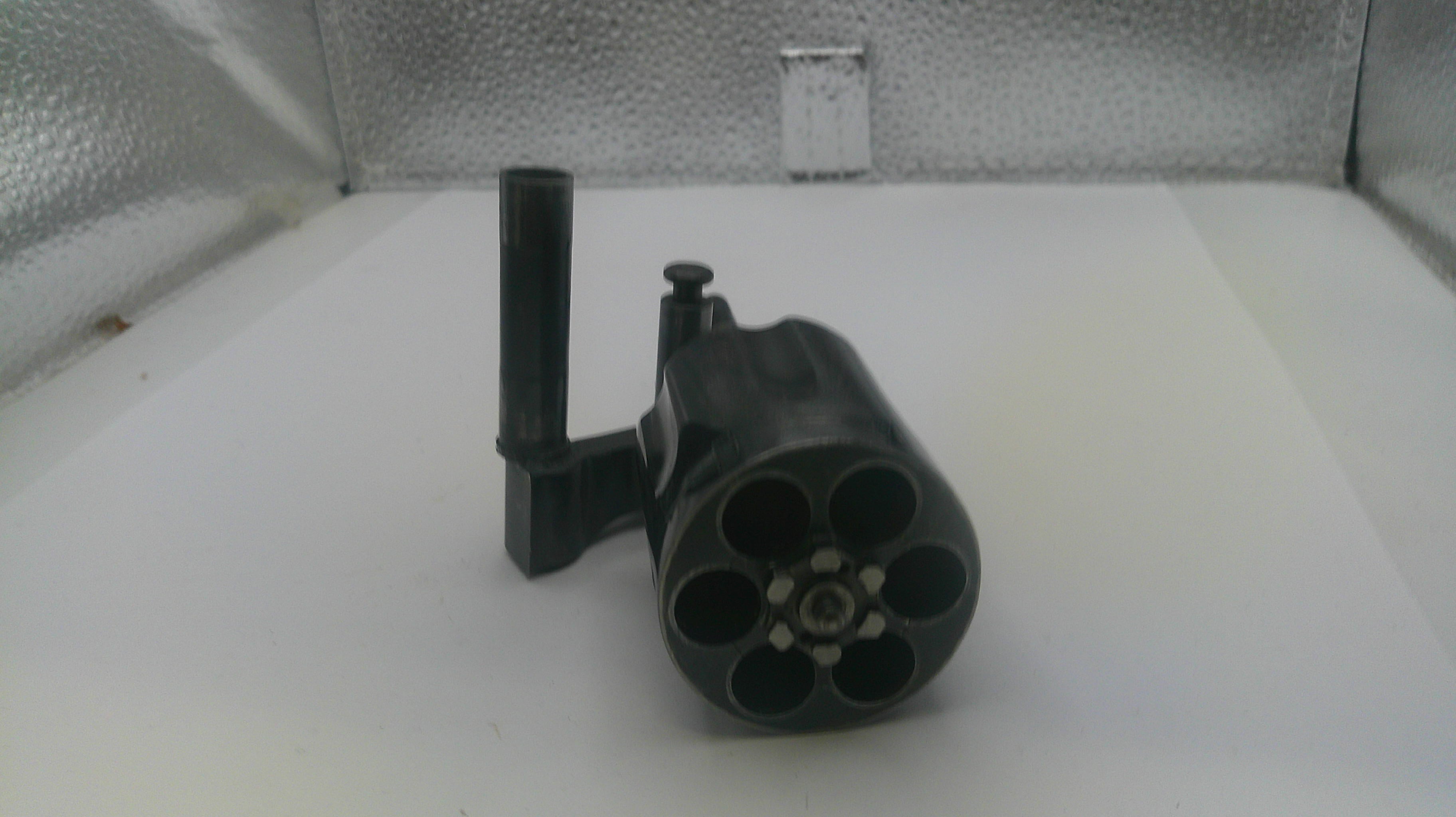 Black cylindrical object with multiple nozzles on a white surface