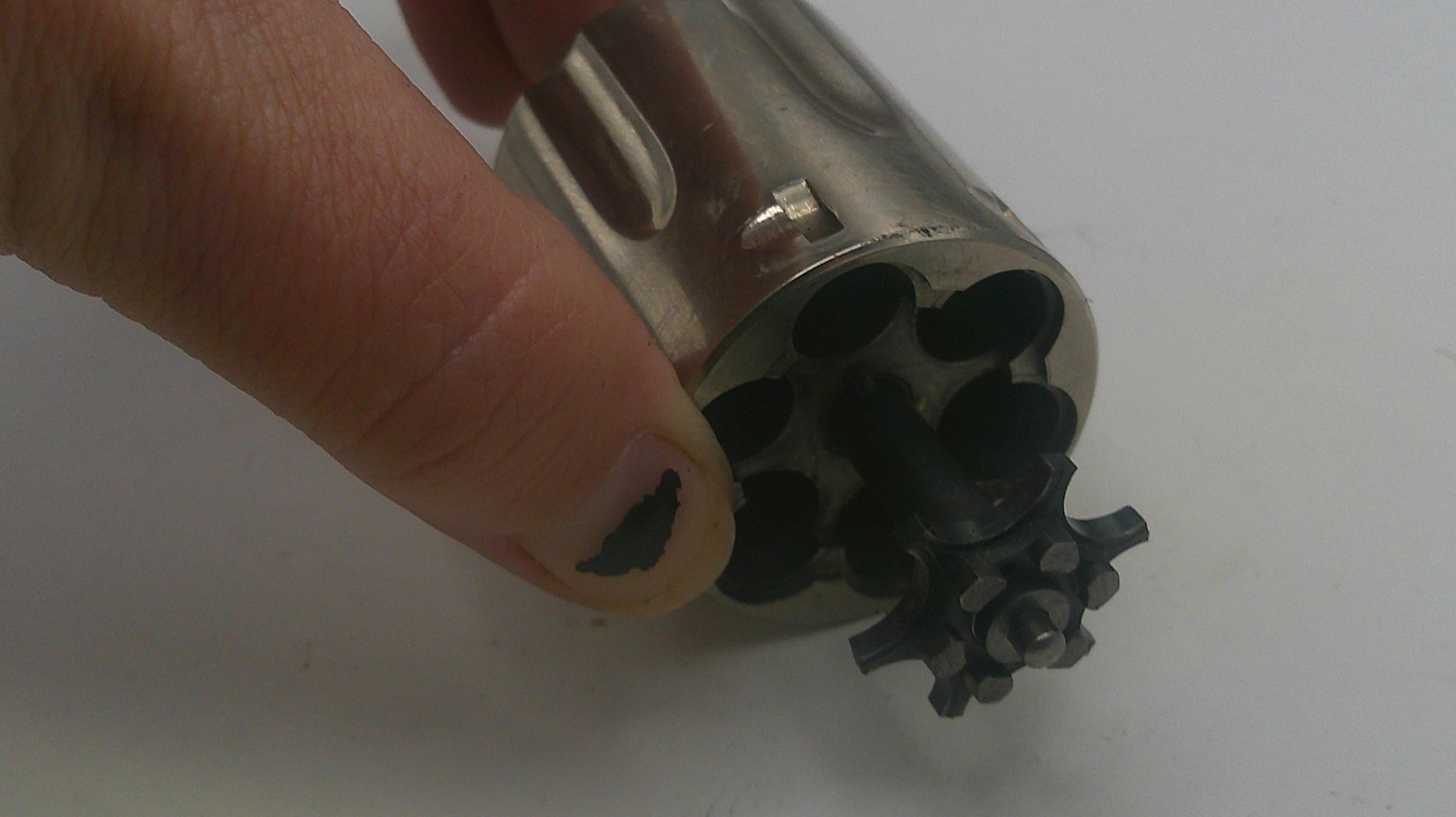 Metallic revolver with multiple barrels held by a hand on a white background
