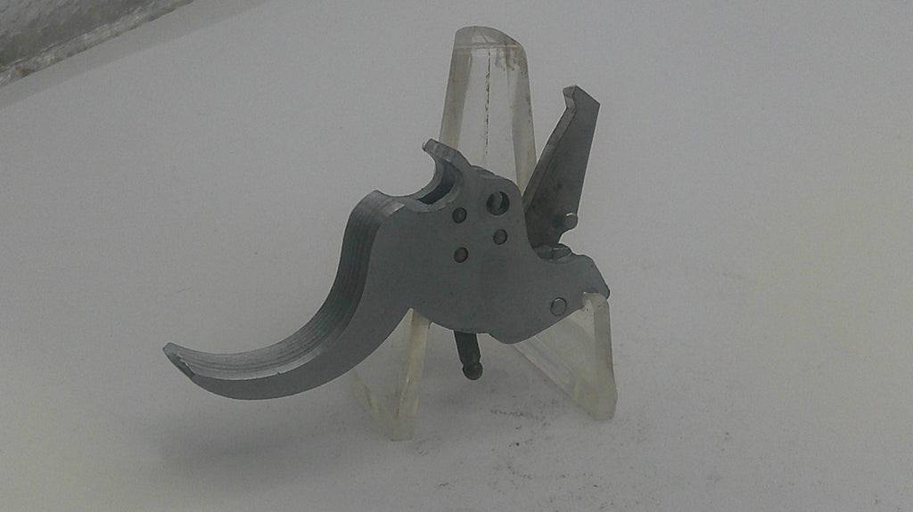 Metallic firearm component on a white background