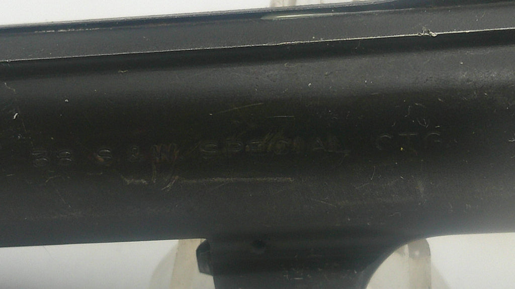 Black metal object with engraved text on a white background