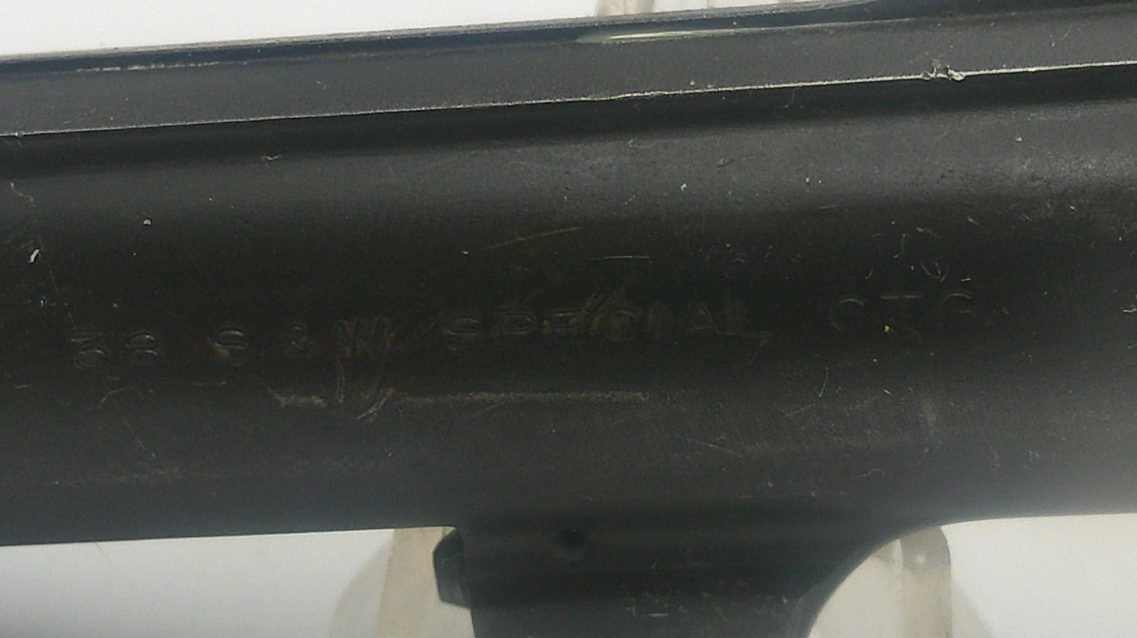 Black metal object with engraved text on a white background