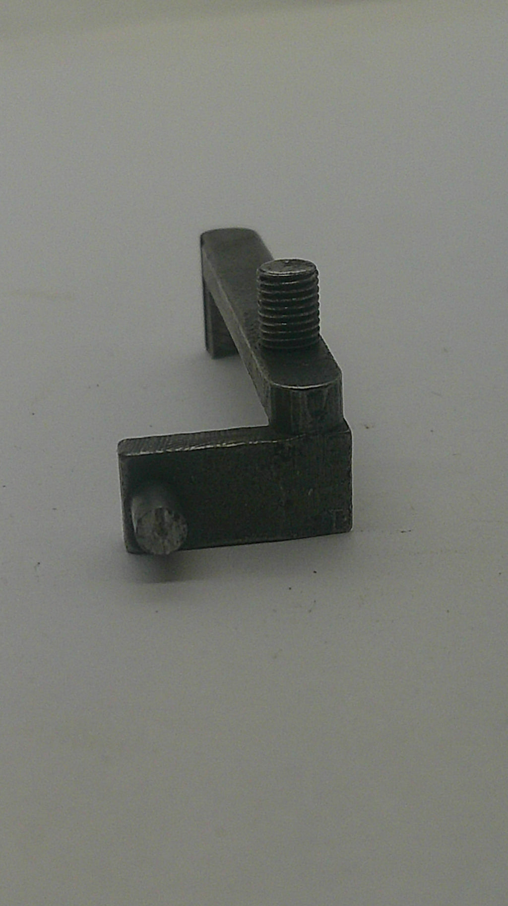 A small dark metal mounting bracket or hardware piece with a threaded bolt, shown against a plain light background.