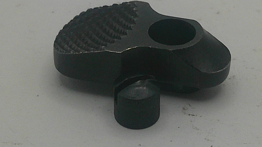 A black metal mechanical component or tool part with a textured surface and a circular opening, photographed on a plain light gray background.