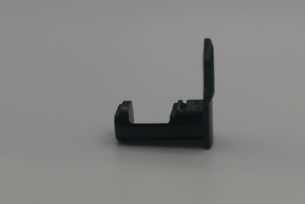 Black plastic component on a white background