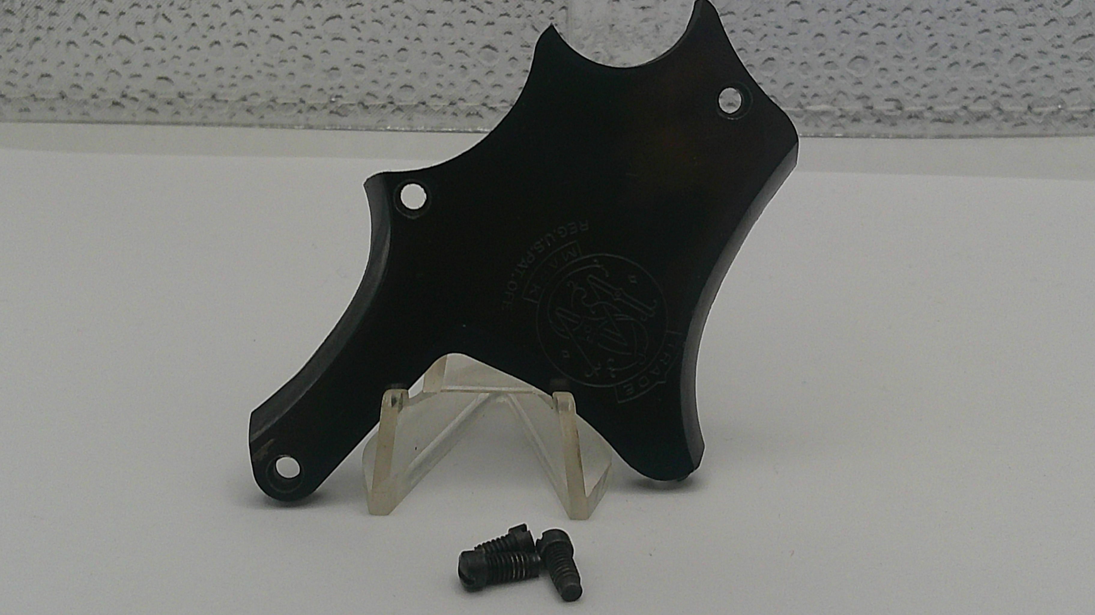 Black guitar pickguard with screws on a white surface