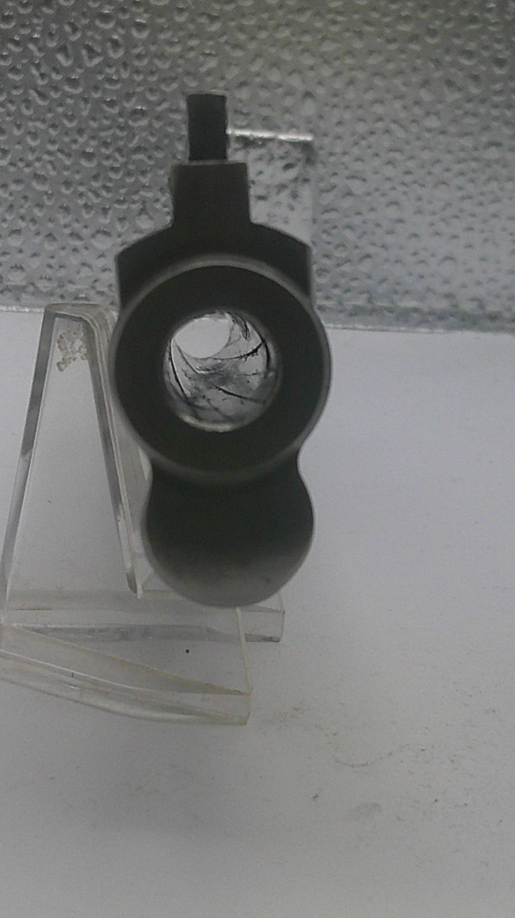Black camera lens on a textured white wall
