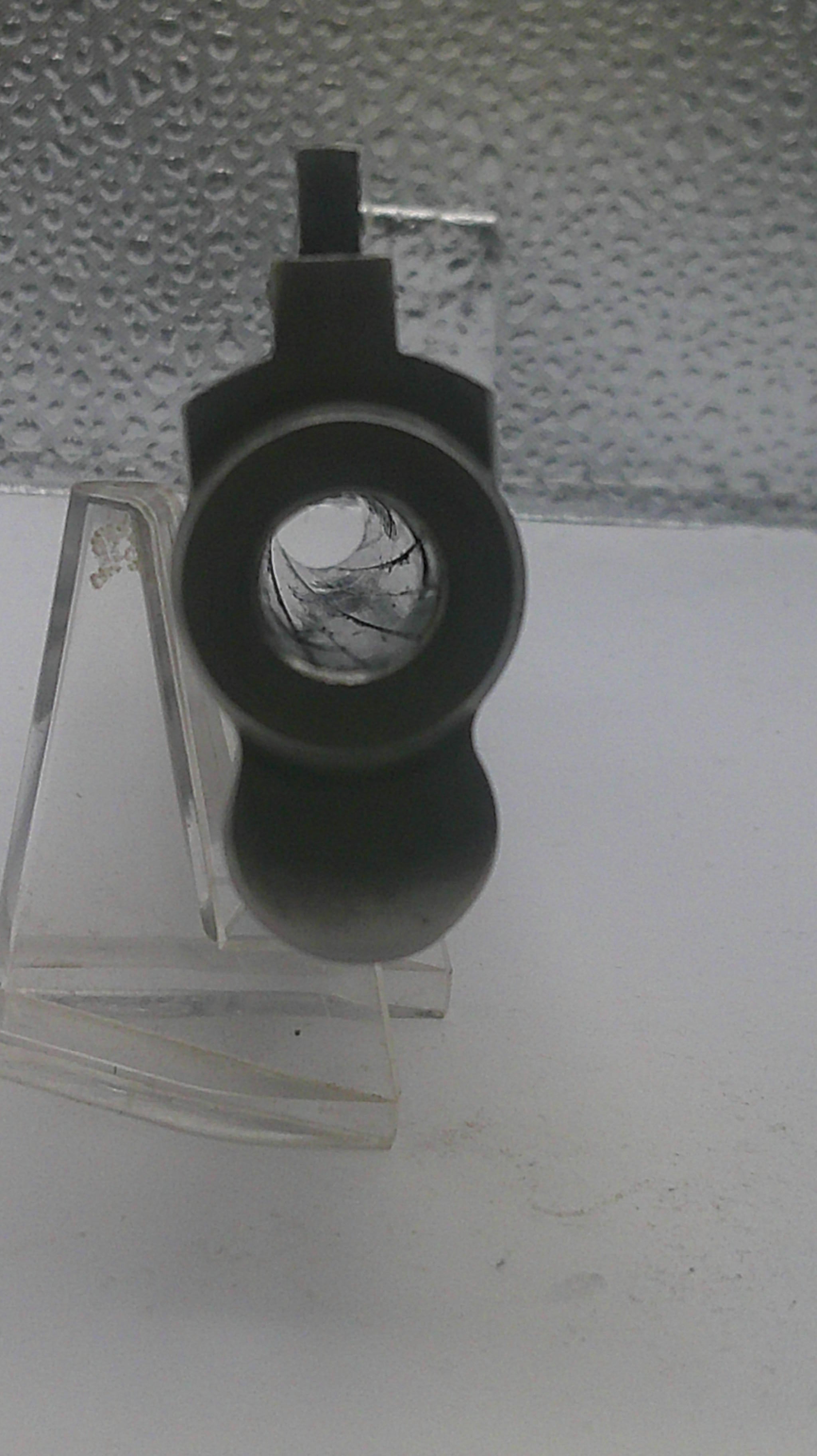Black camera lens on a textured white wall