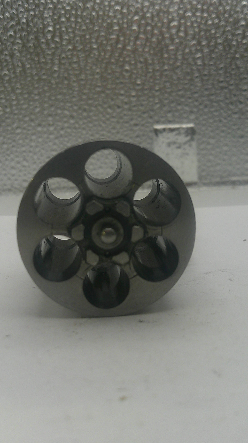 Black metal component with multiple holes on a textured surface