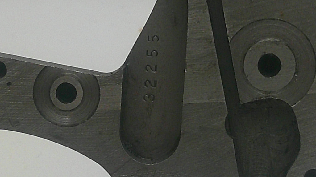Metal component with embossed number '32255' on a blurred background