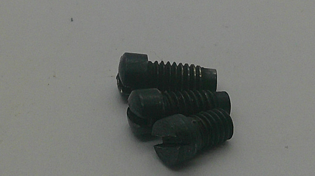 Three small black plastic slotted screws with threaded bodies, arranged on a plain light gray surface.