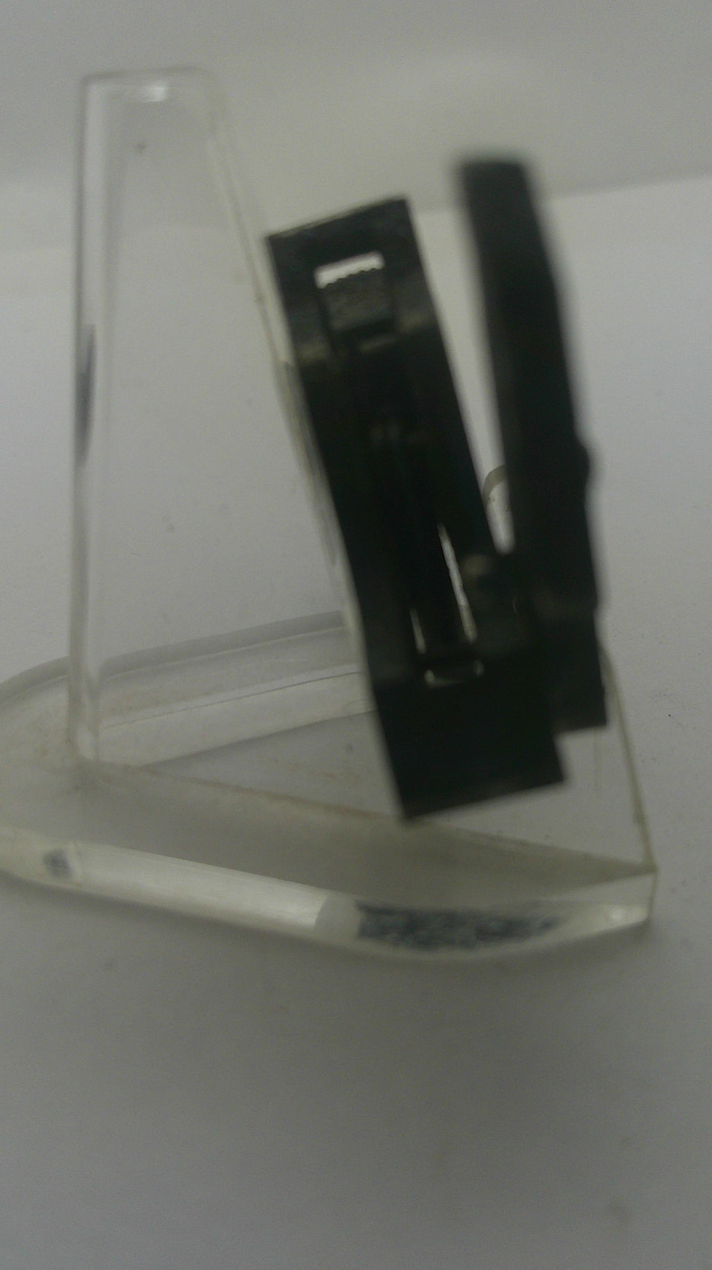 A clear plastic mounting bracket or shelf clip with a black metal support bar inside, shown against a plain light background.