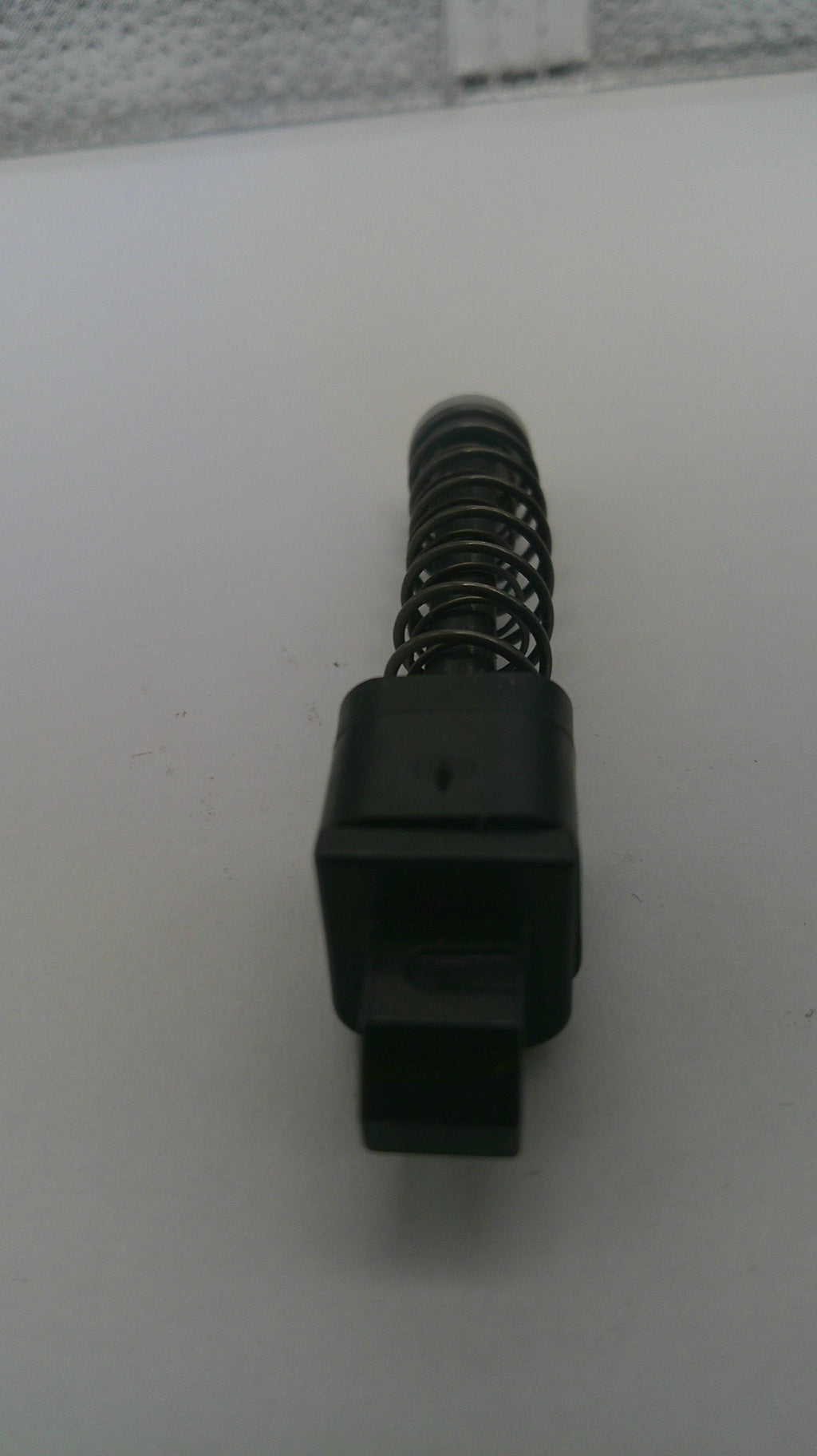Black spring-loaded mechanism on a white background