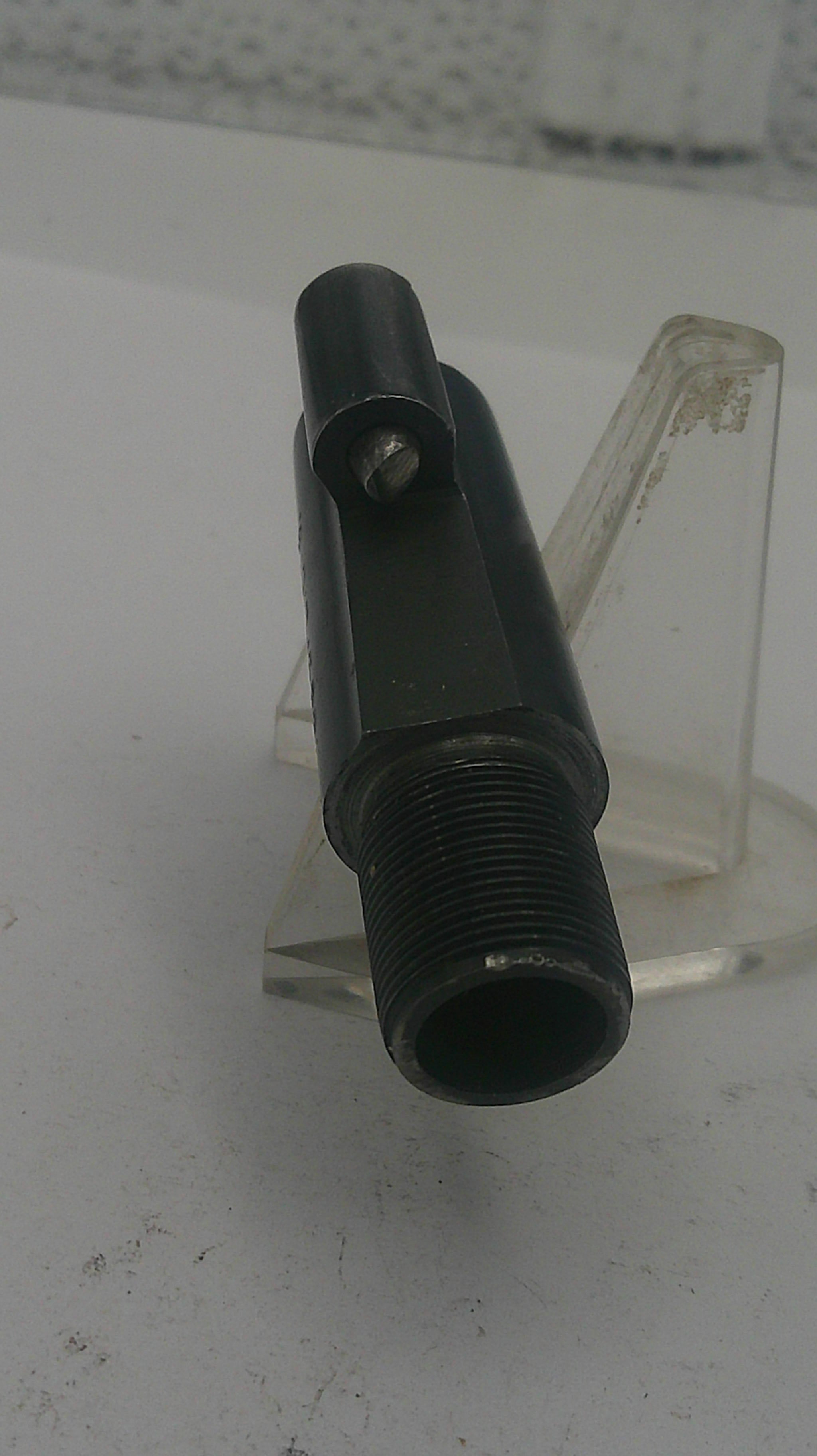 Black metal fitting on a clear stand against a white background