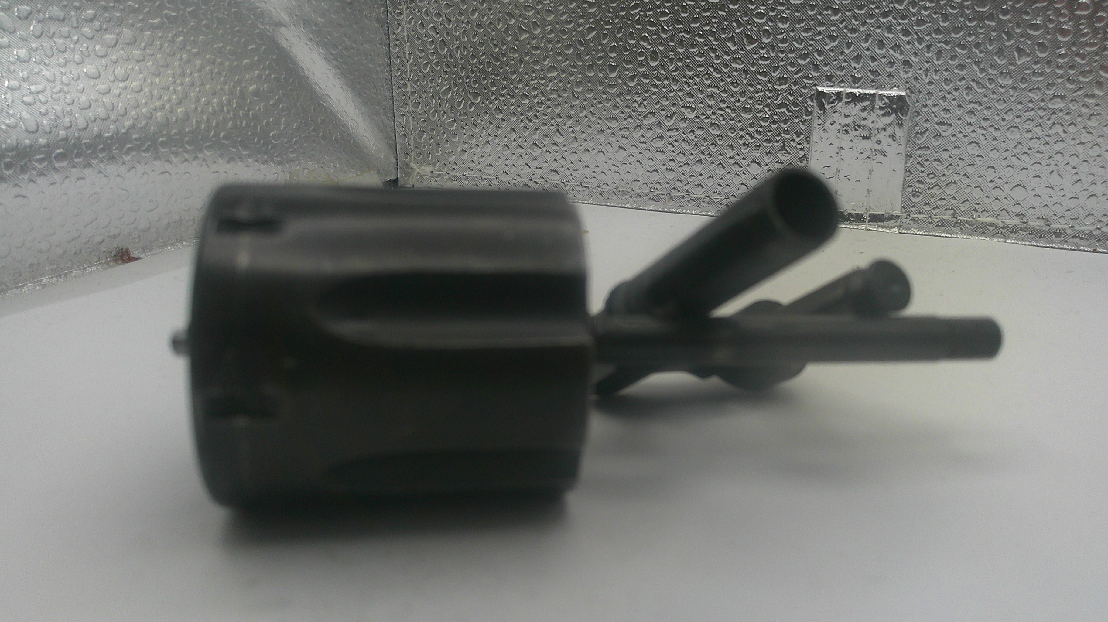 Black mechanical component on a white surface with a textured gray background