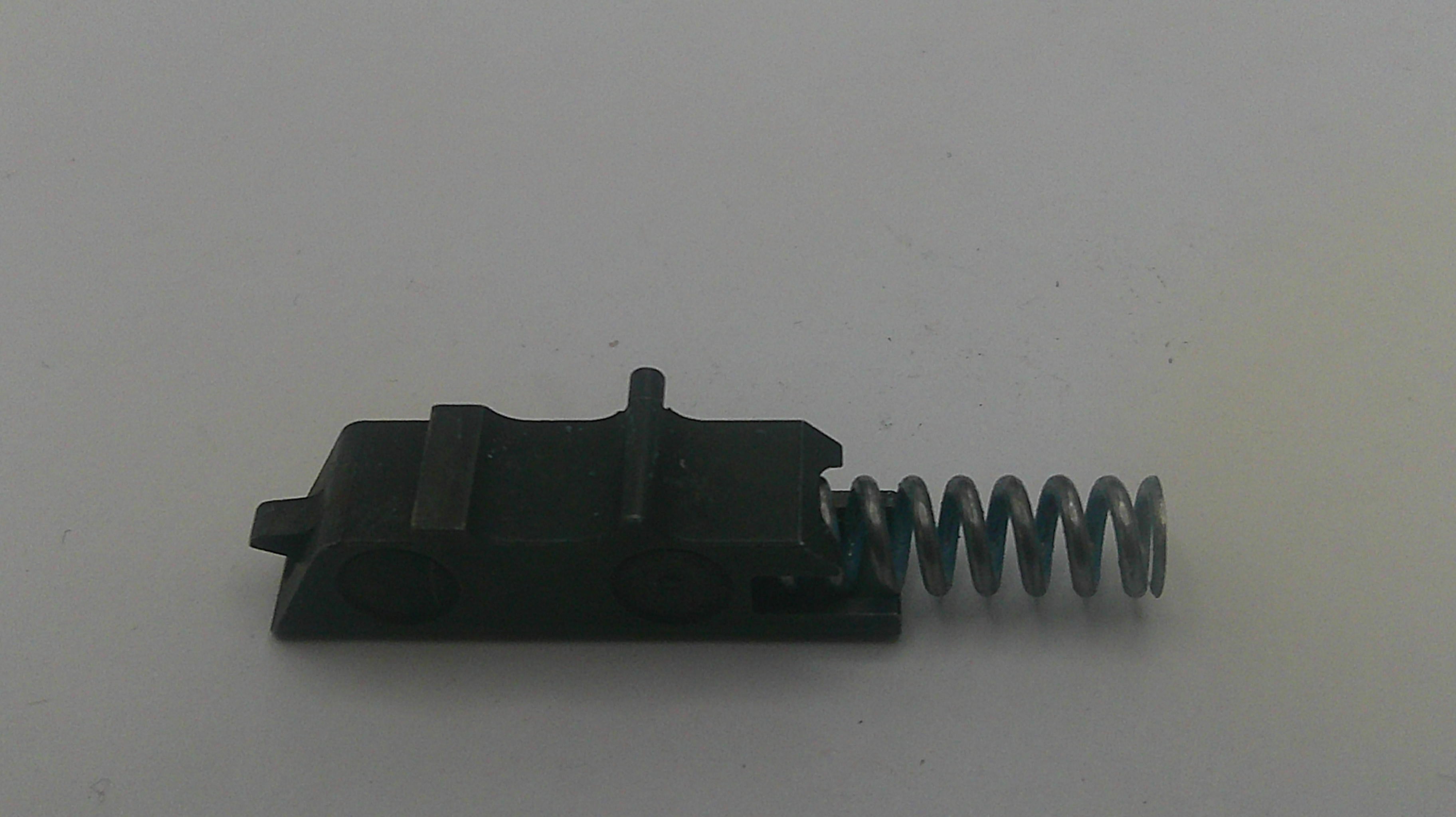 Black mechanical component with a spring on a white background