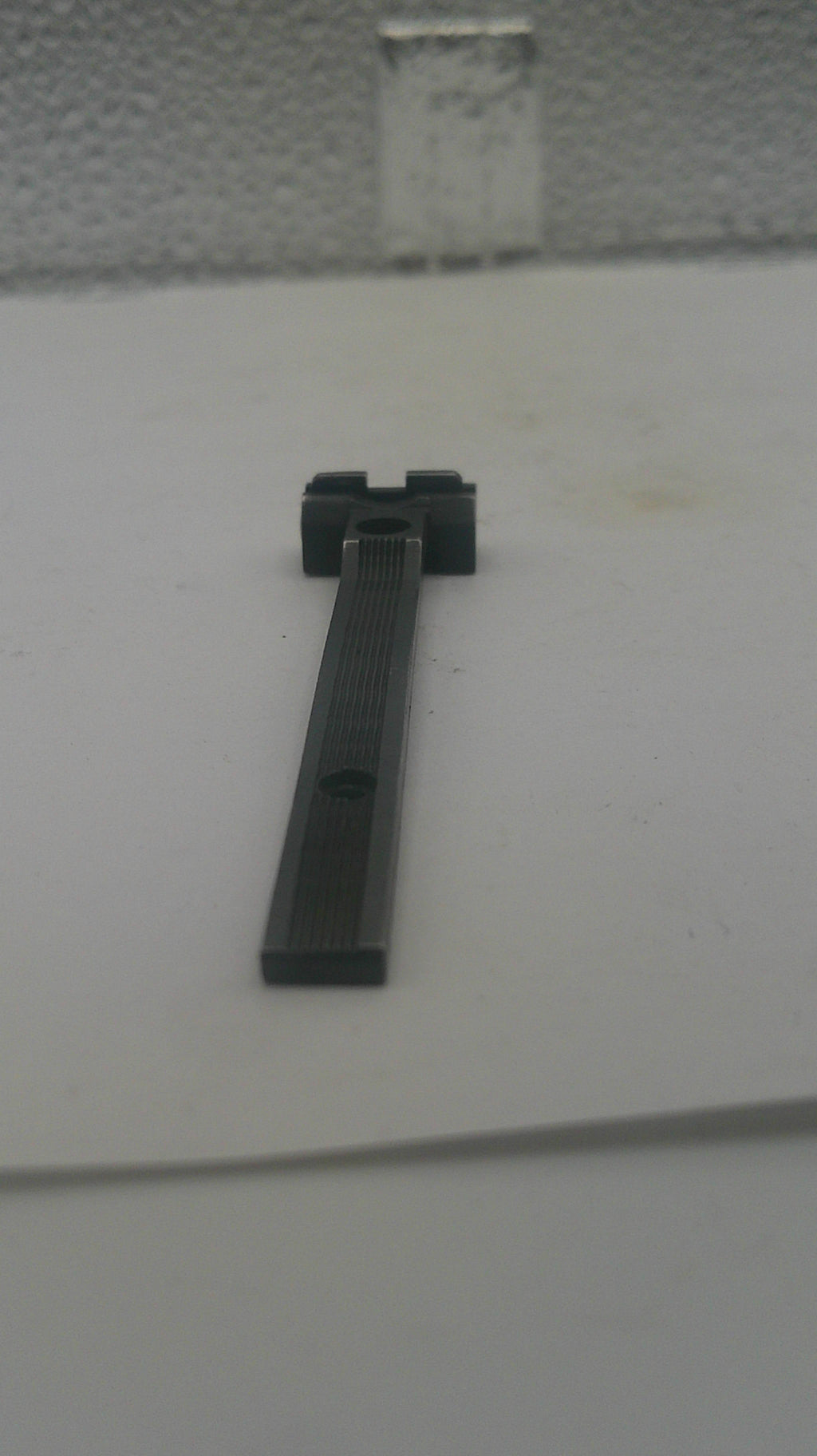 A black metal door stopper mounted on a white door, shown in a close-up view.