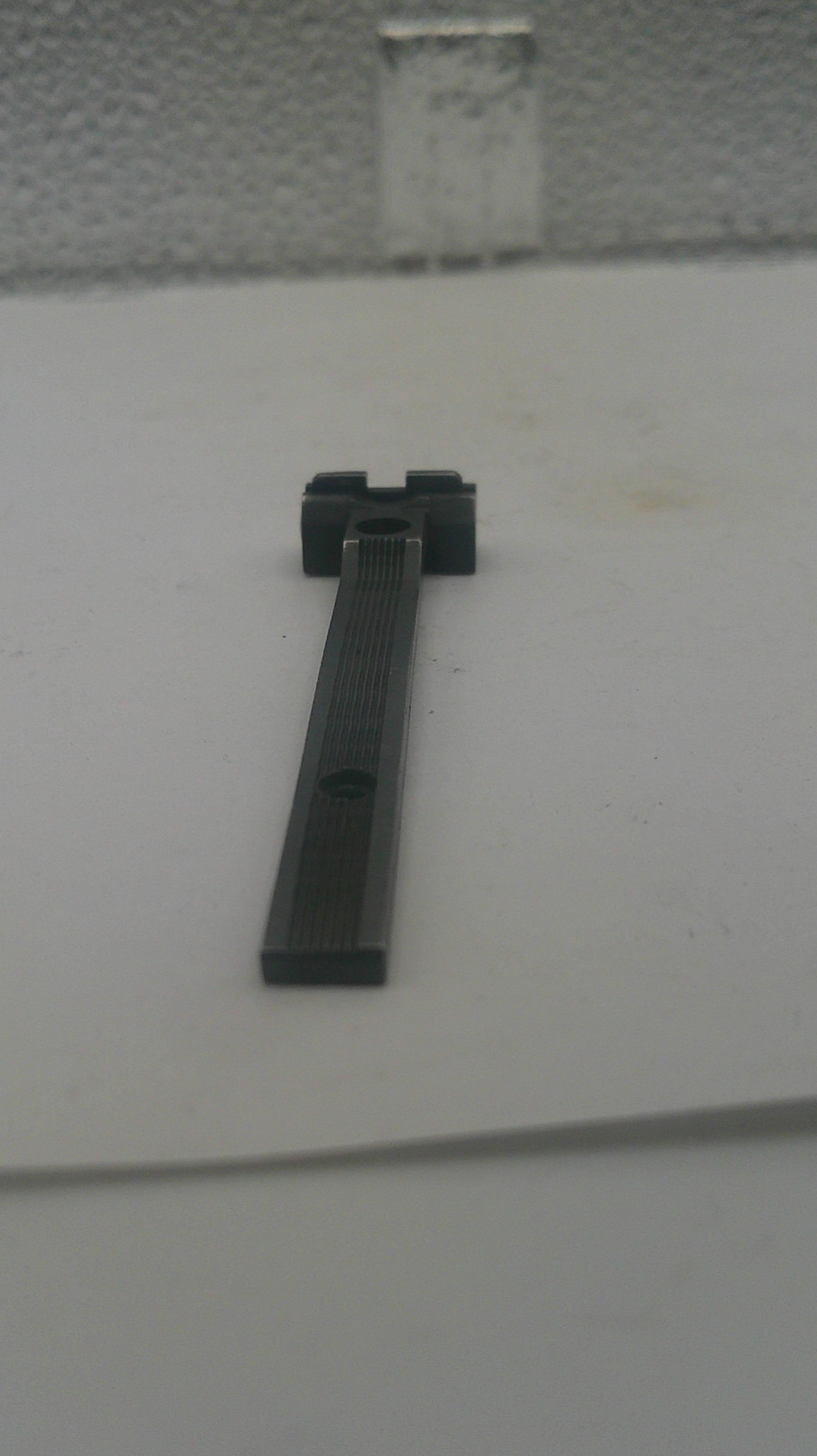 A black metal door stopper mounted on a white door, shown in a close-up view.