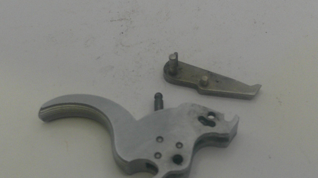 Metallic firearm components on a light gray background