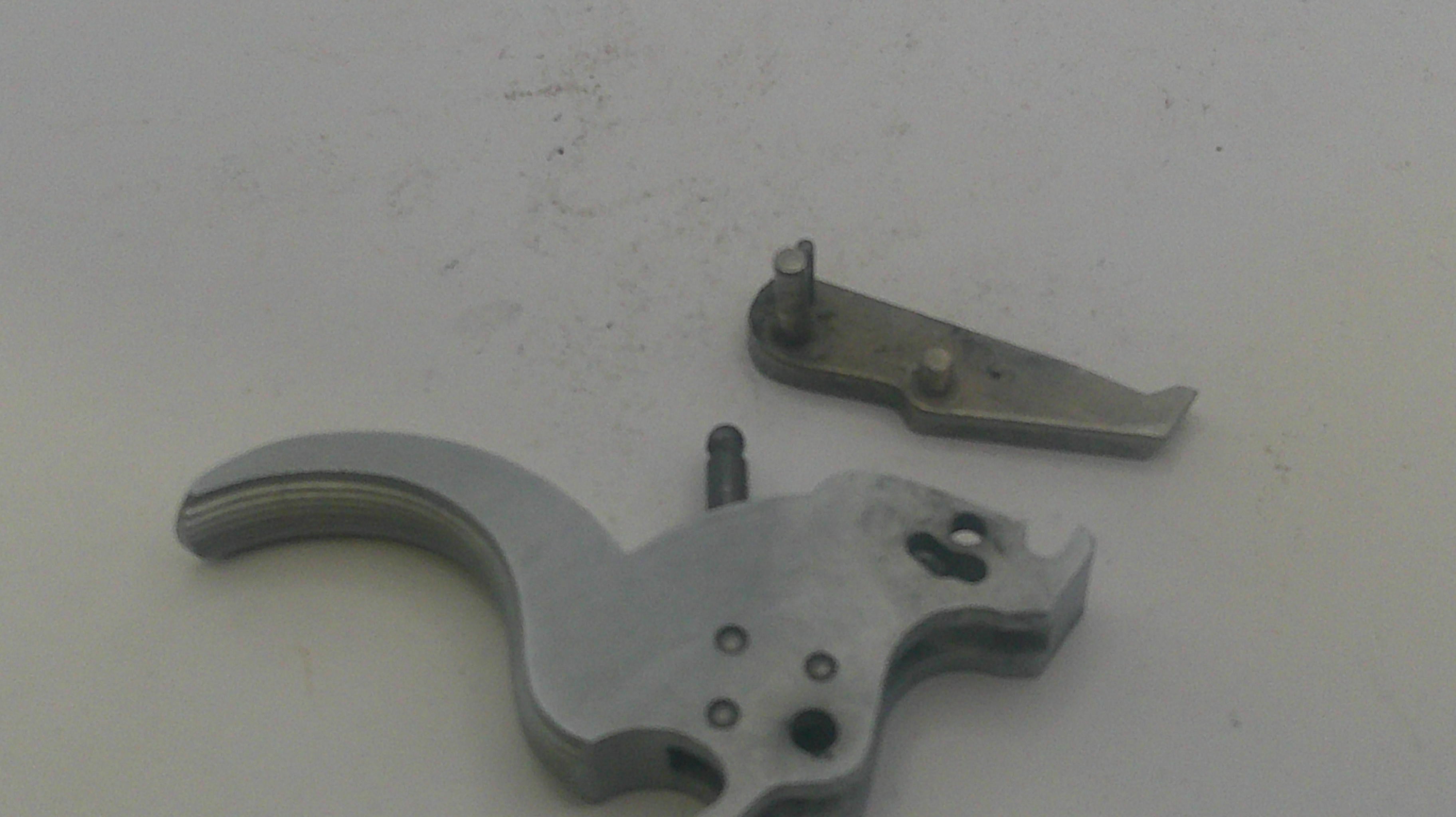 Metallic firearm components on a light gray background