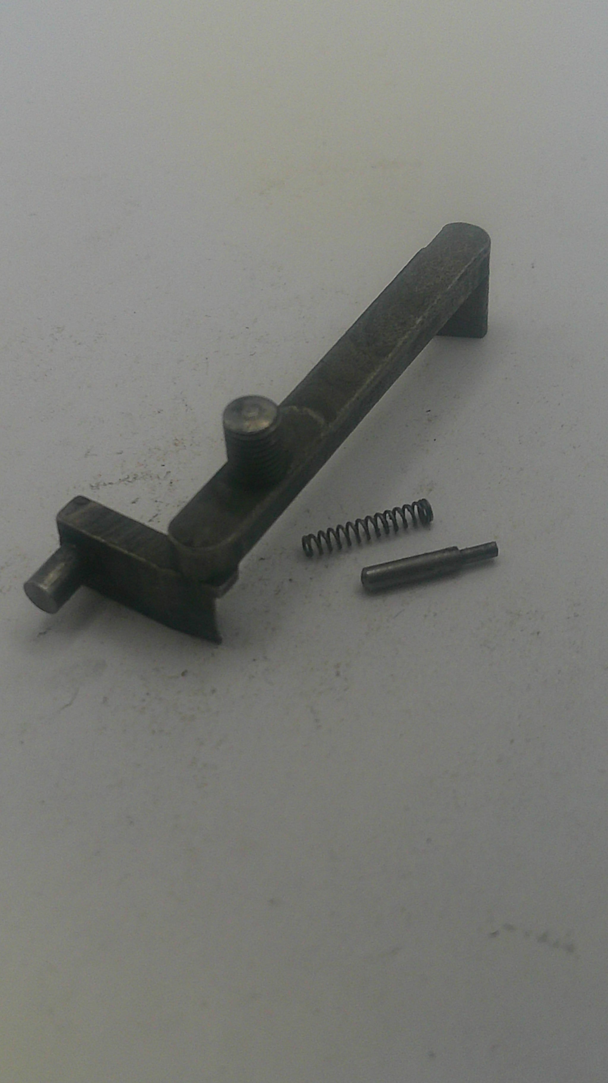 Metal components including a bolt, spring, and cylindrical part on a white background