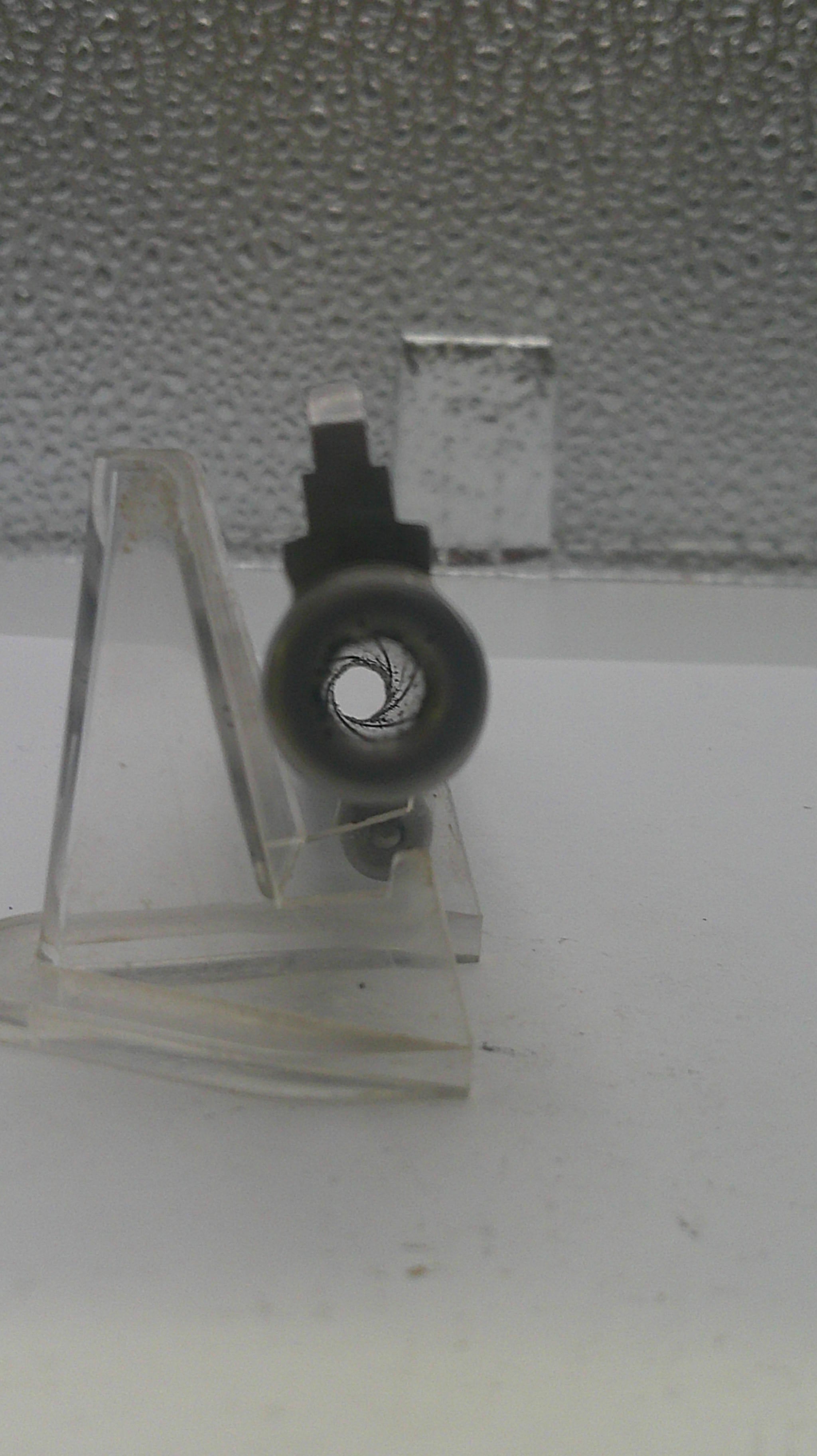 Small metal stand with a wheel on a textured surface
