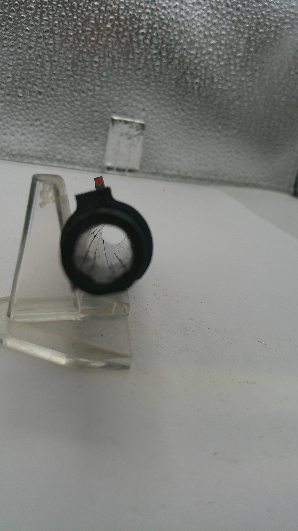 Small pressure gauge on a white surface with a textured gray background