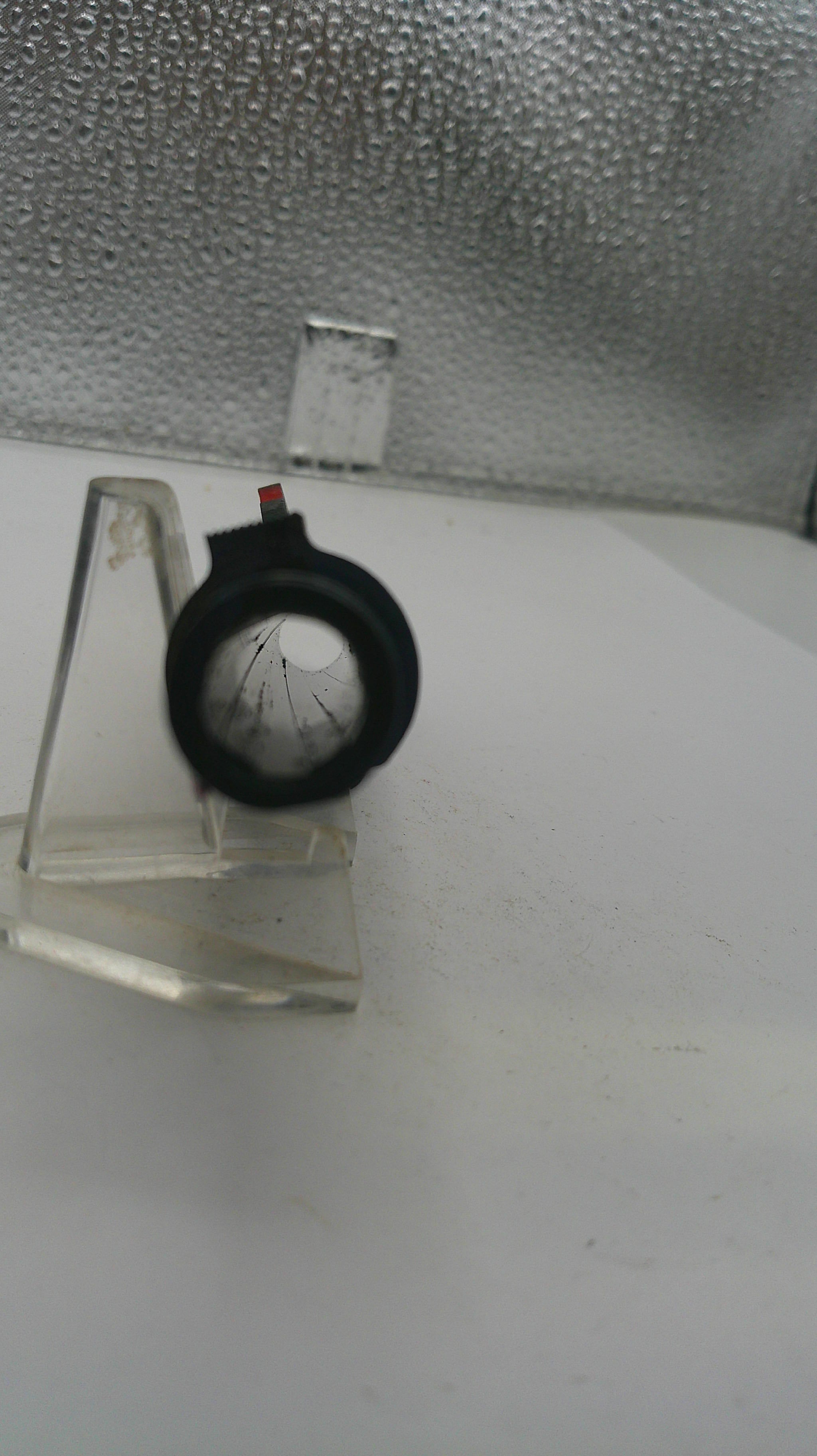 Small pressure gauge on a white surface with a textured gray background
