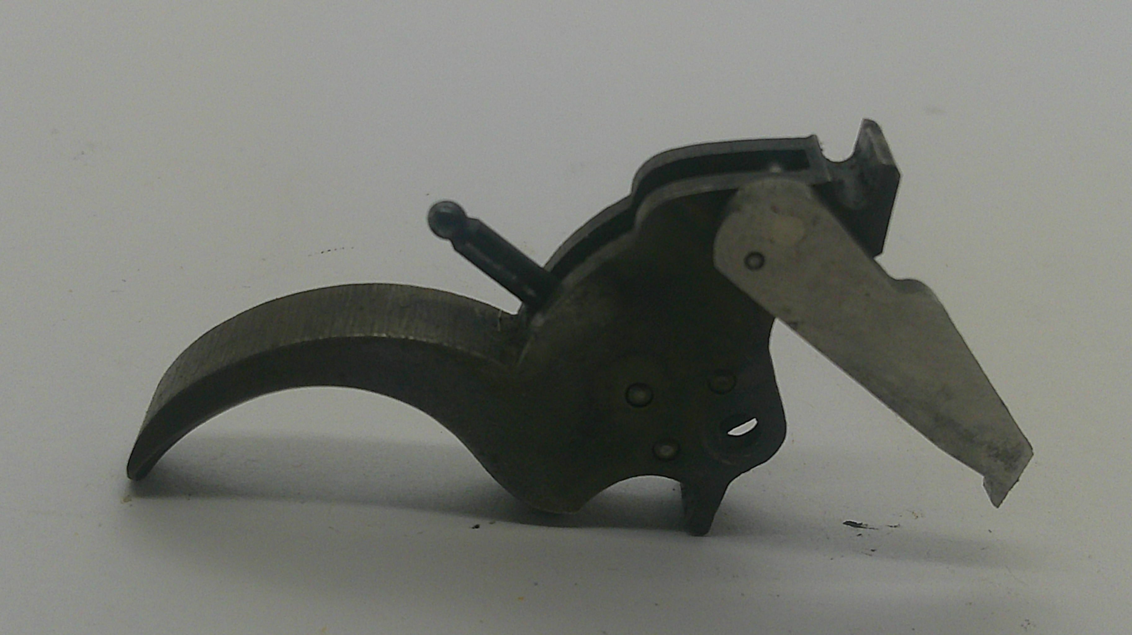 A close-up of a dark metal mechanical component with a curved arm and a flat rectangular lever, photographed on a plain light background.