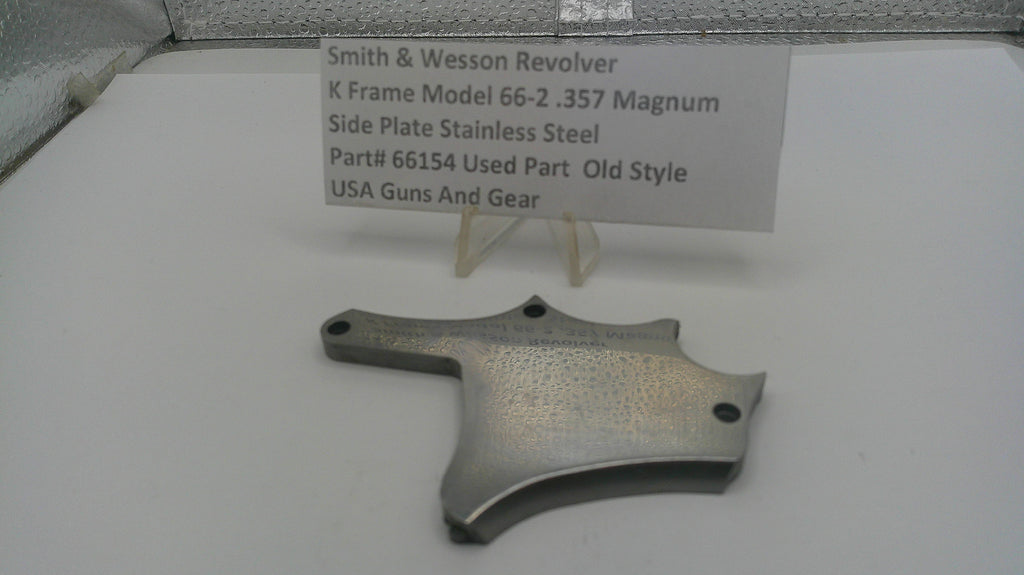 Smith & Wesson revolver side plate on a white surface with a label.