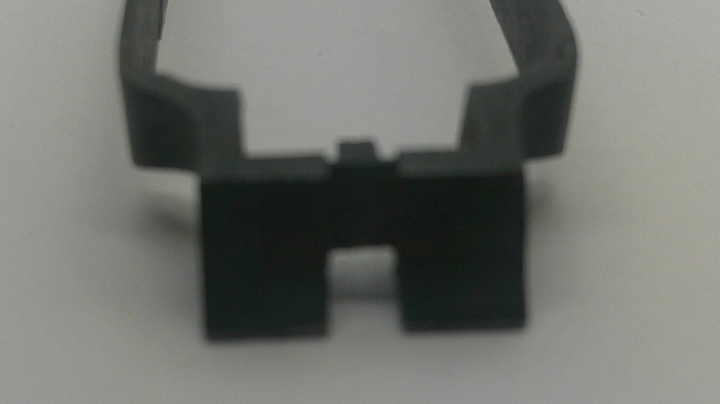A close-up of a small black plastic or rubber clip-like component on a plain light background.