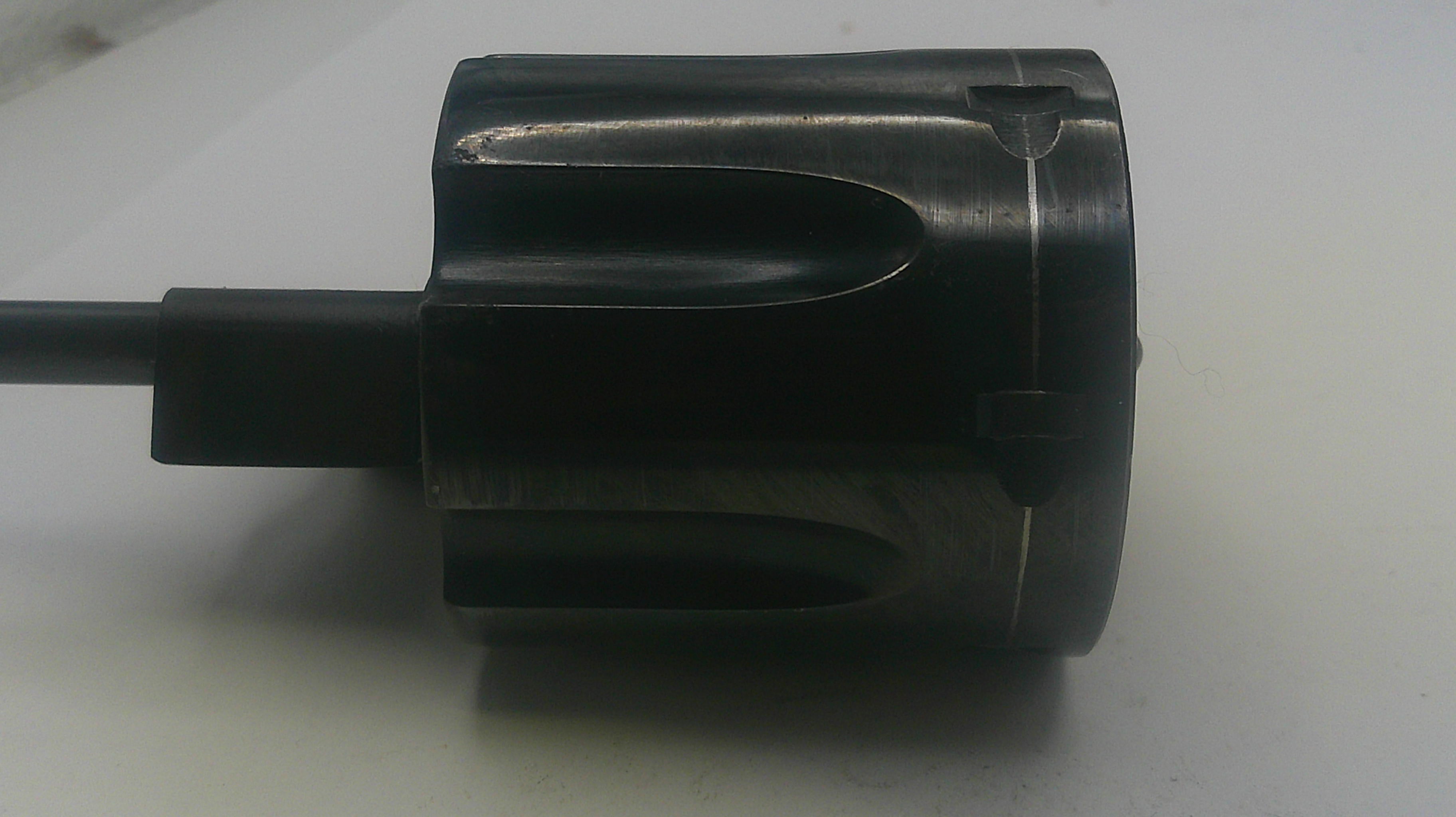 Black cylindrical object with a handle on a light gray background