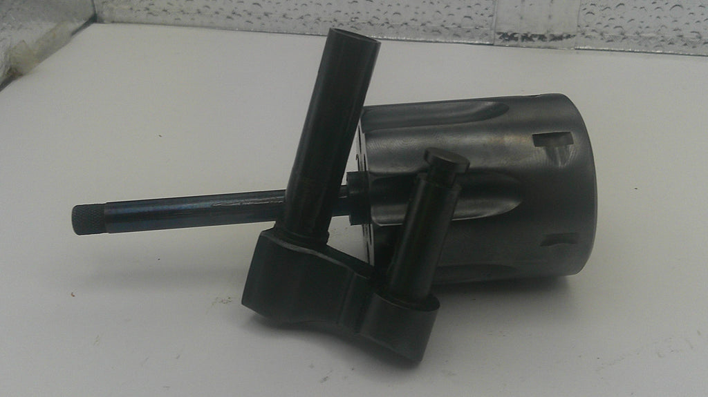 A black plastic and metal mechanical component, possibly a filter or connector part, resting on a white surface.