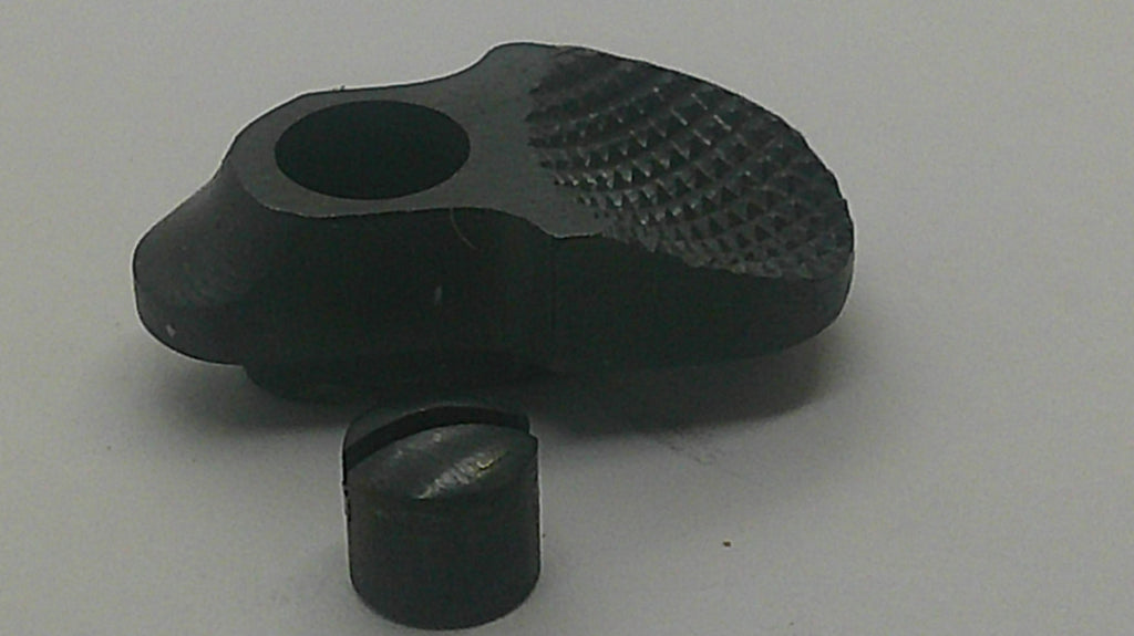 A black textured plastic or rubber grip piece with a circular hole, shown alongside a small matching black cylindrical cap or insert on a plain light gray background.