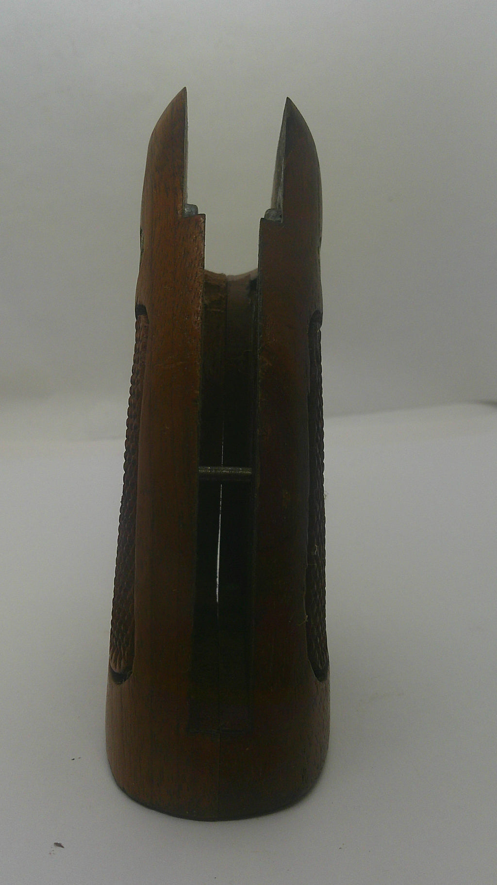 A vintage wooden bowfishing arrow nock with a dark brown wood finish and a silver metal barbed point, shown against a plain off-white background.