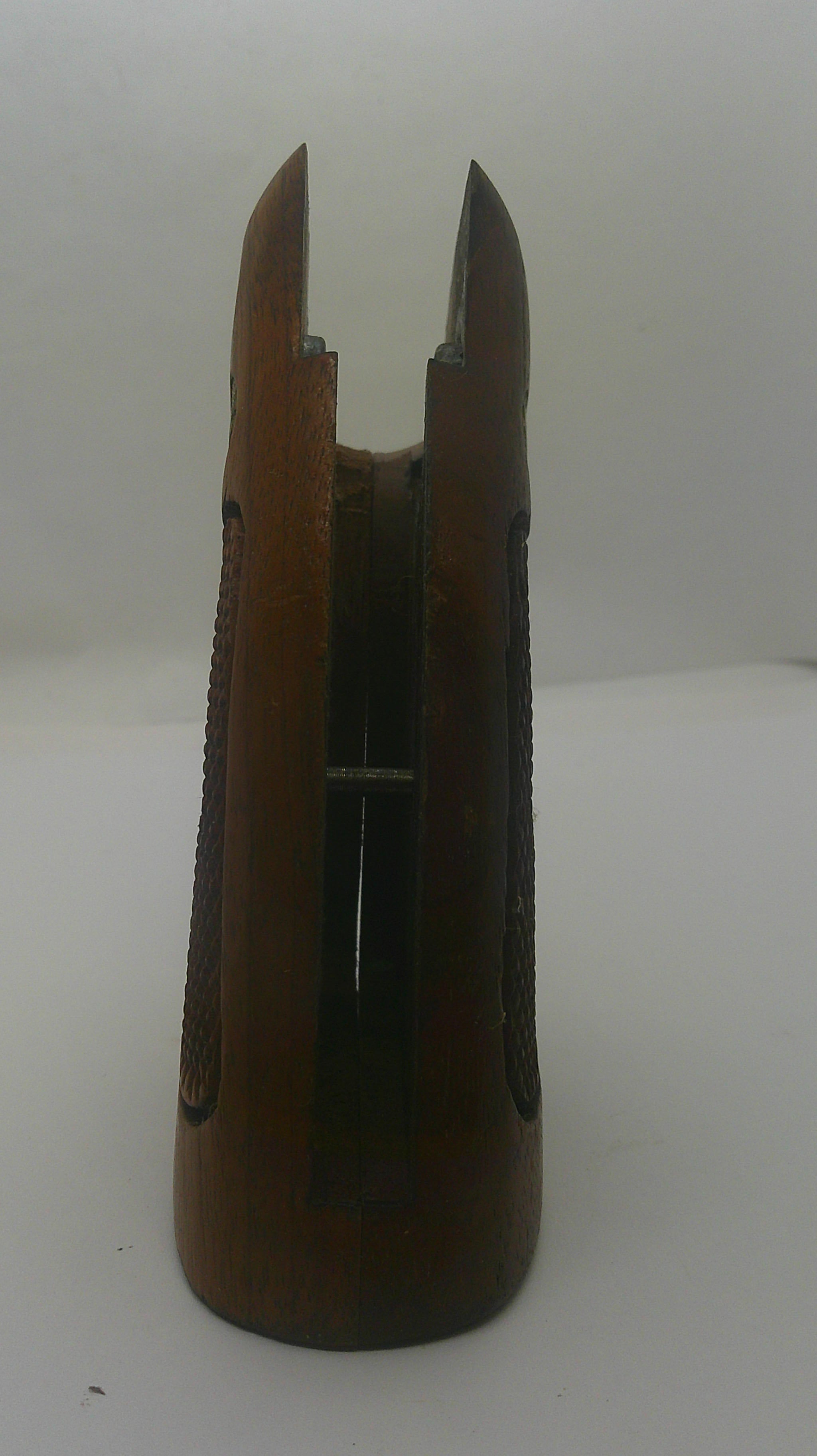 A vintage wooden bowfishing arrow nock with a dark brown wood finish and a silver metal barbed point, shown against a plain off-white background.