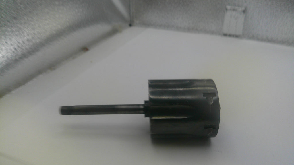Black cylindrical object with a long shaft on a white surface