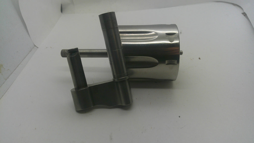 A metallic mechanical part, possibly a motor or engine component, featuring a shiny silver cylindrical body and dark gray mounting brackets, resting on a white surface.