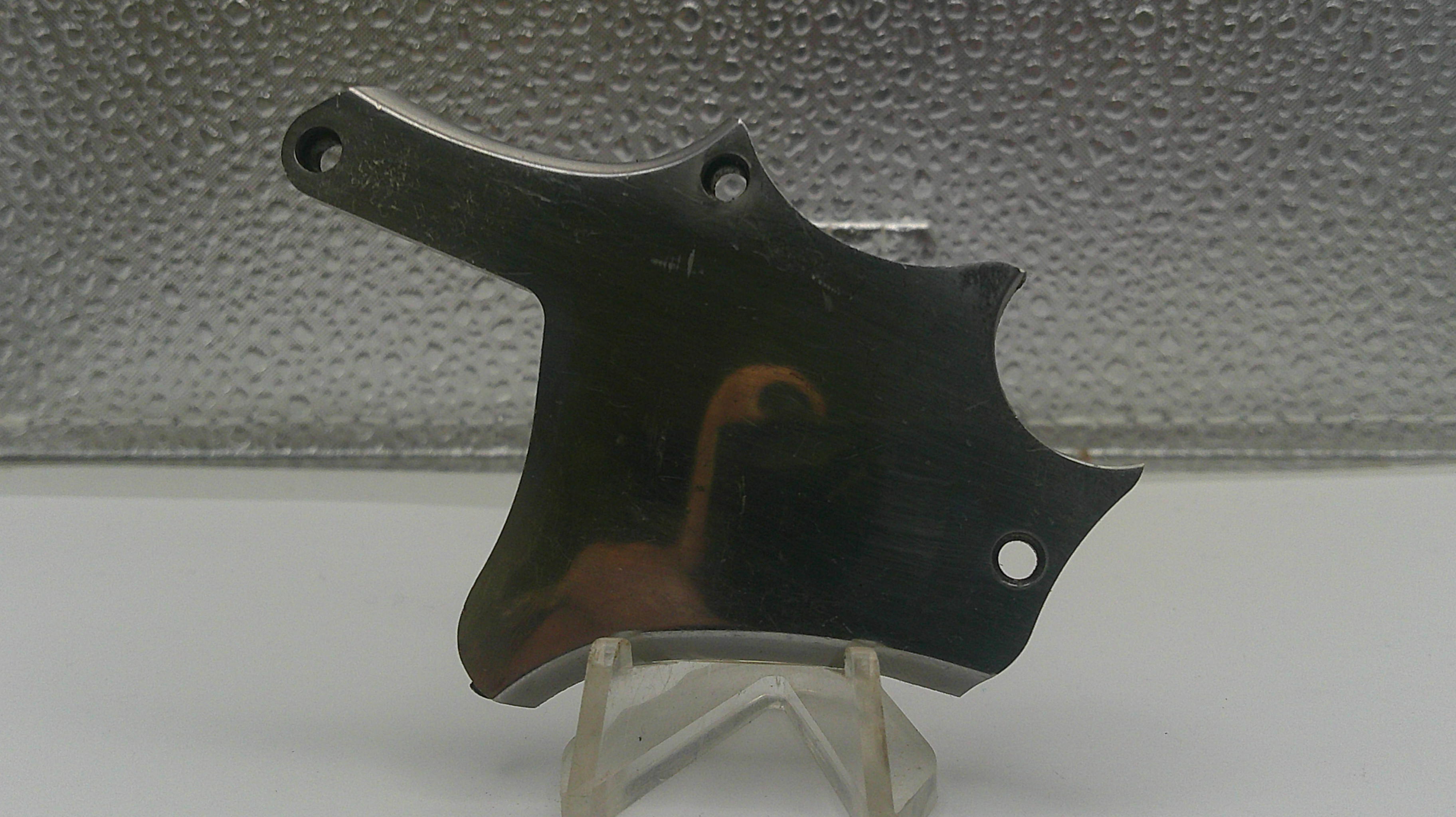 Metallic object on a stand against a textured gray background