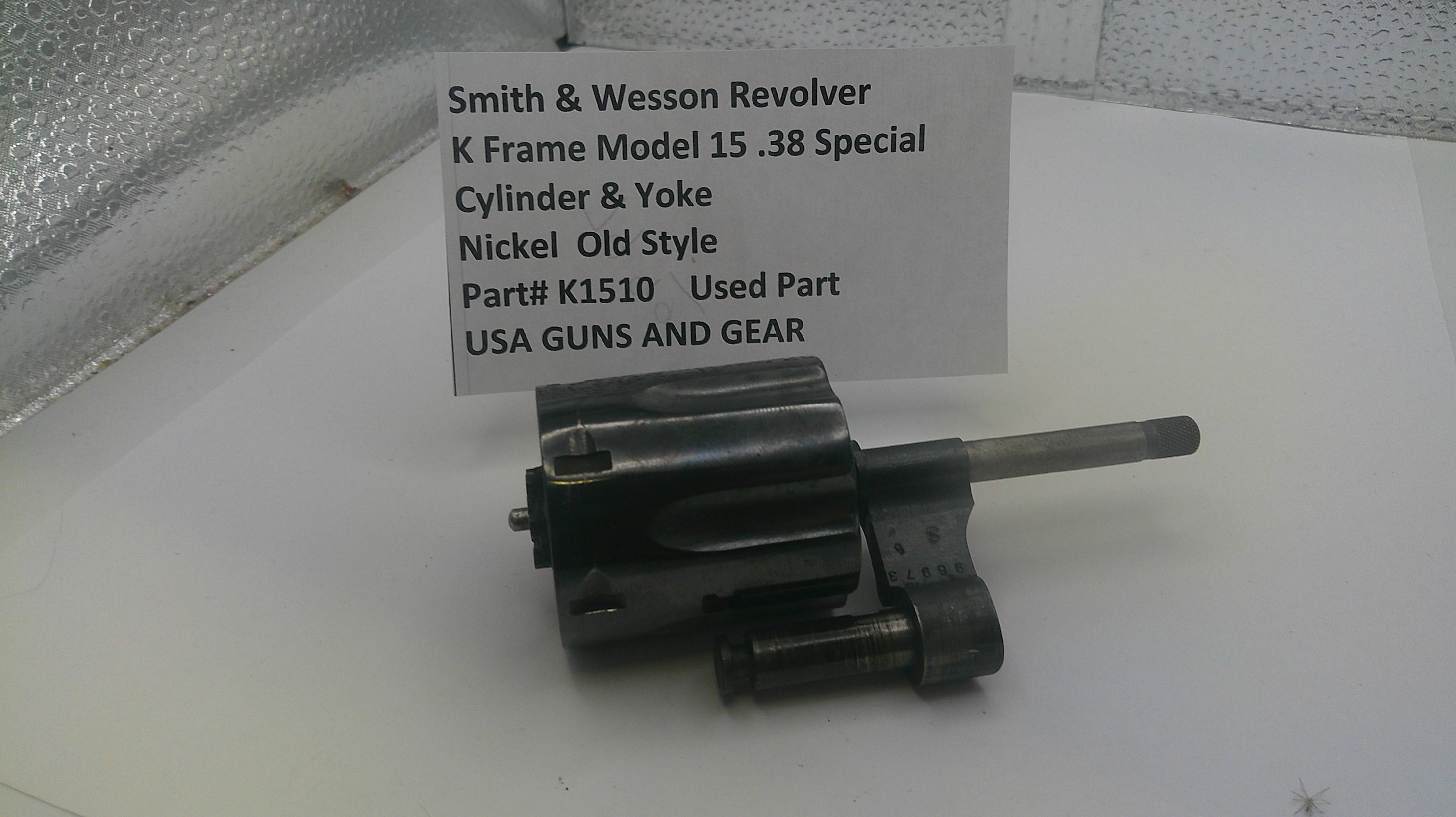 Smith & Wesson revolver cylinder and yoke on a white surface with a label.