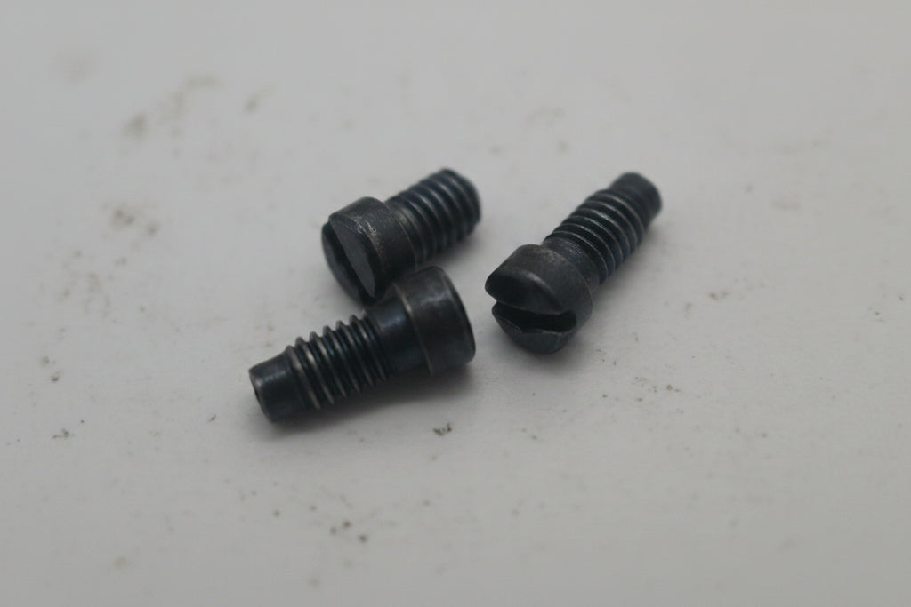 Three black screws on a white surface