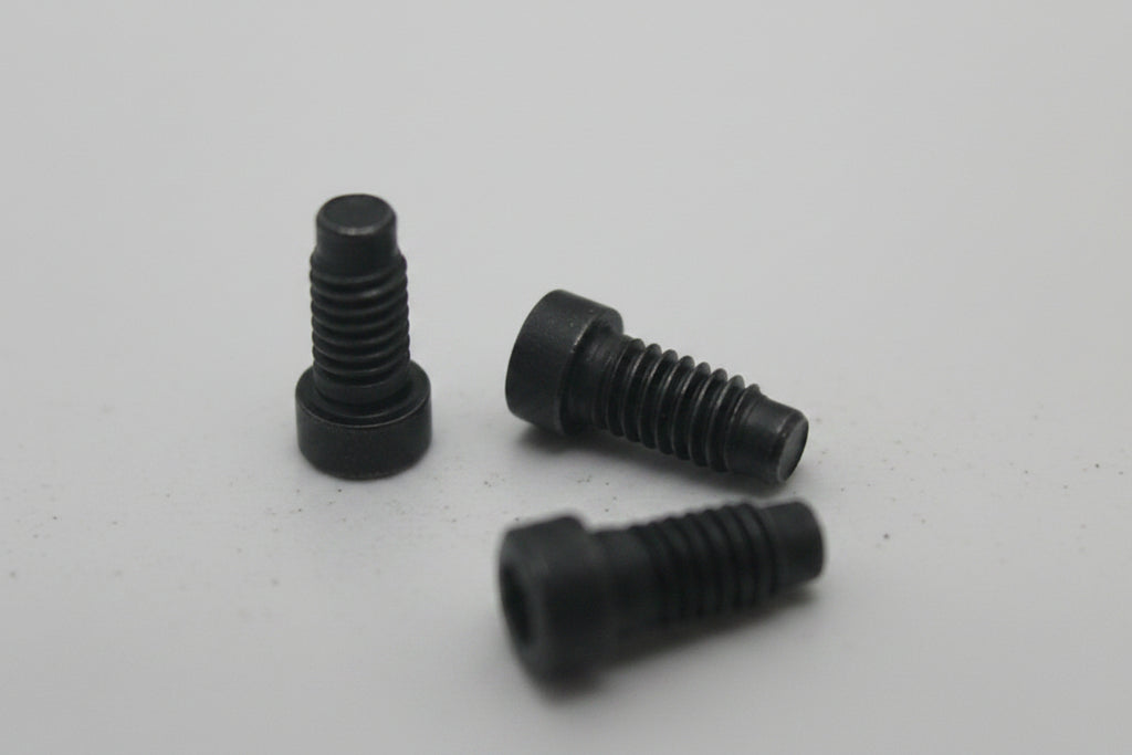 Three black screws on a white surface
