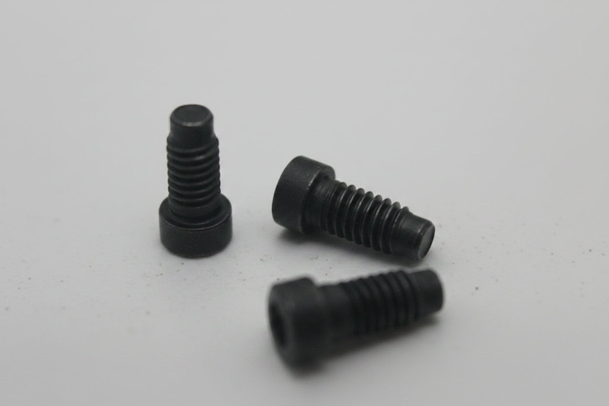 Three black screws on a white surface