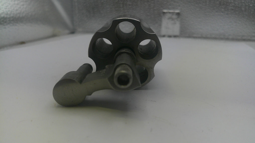 Metallic mechanical component on a white surface with a textured background