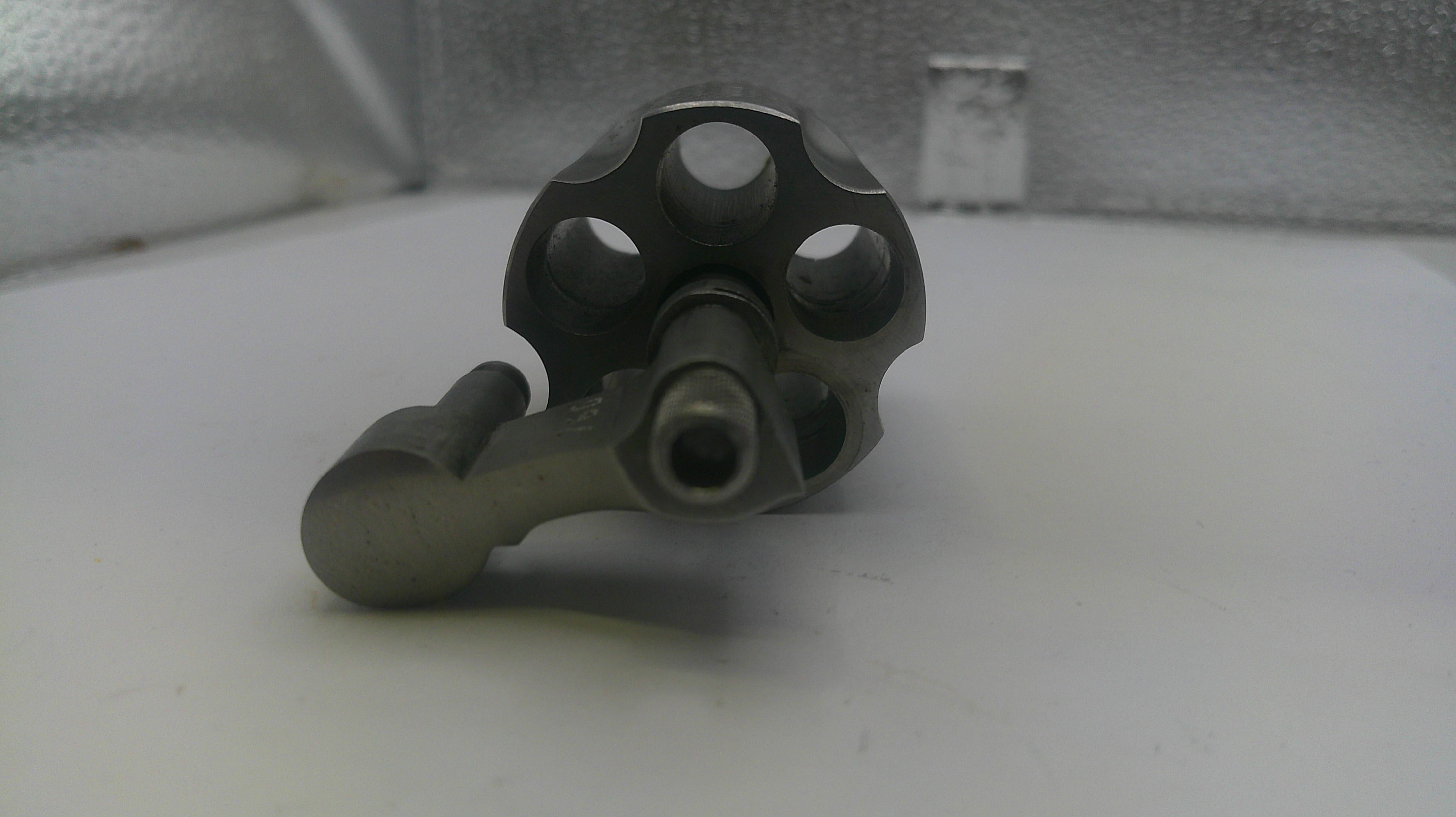 Metallic mechanical component on a white surface with a textured background
