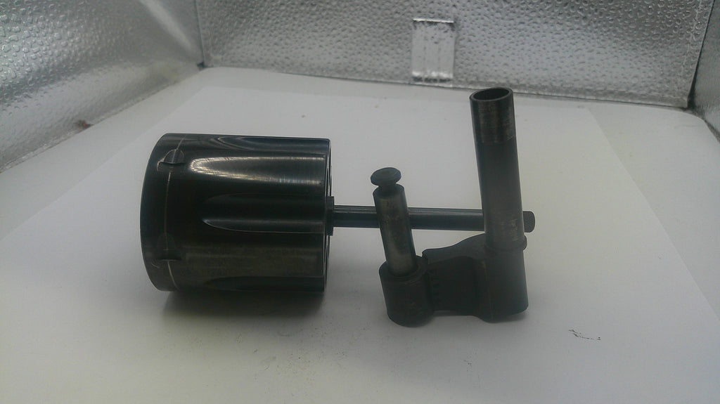 Black mechanical component on a white surface with a metallic background